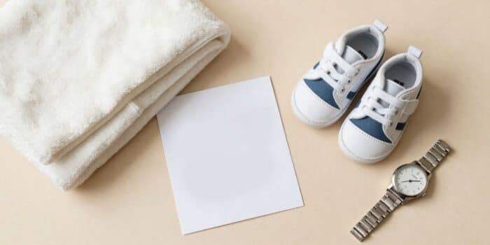 Congrats on becoming a father messages image with baby shoes, blanket, and congratulatory card.