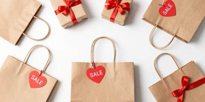 Valentine’s Day shopping quotes image with gift bags, sale tags, and heart decorations.